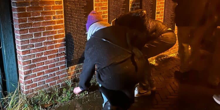 Twee mensen leggen een steentje bij het Joods monument. Er werden ook bloemen, en kaarsjes achter gelaten - Haarlem105 / Brecht van Groen